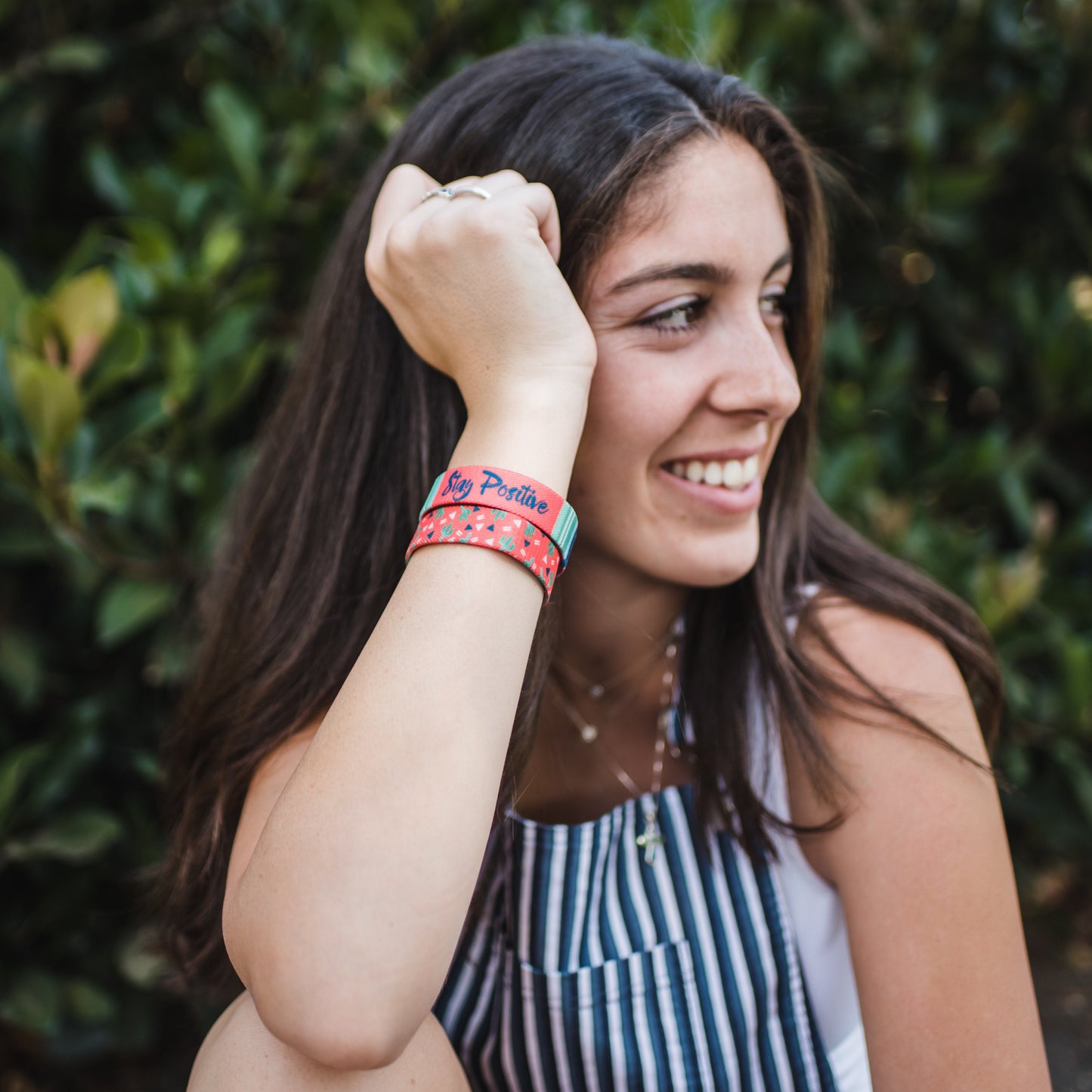 Lifestyle image of someone smiling with 2 Stay Positive on their wrist