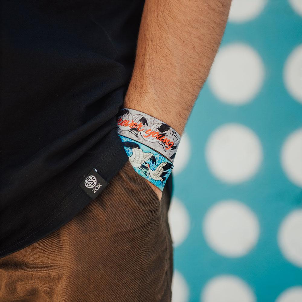 Studio image close up of model's hand in pocket with 2 Forever Young on wrist