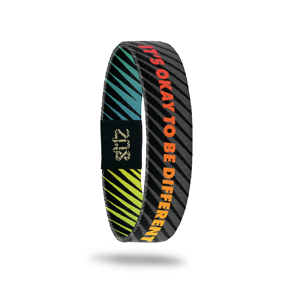 Outside Design of It’s Okay To Be Different: black and grey striped design with rainbow text ‘It’s Okay To Be Different’