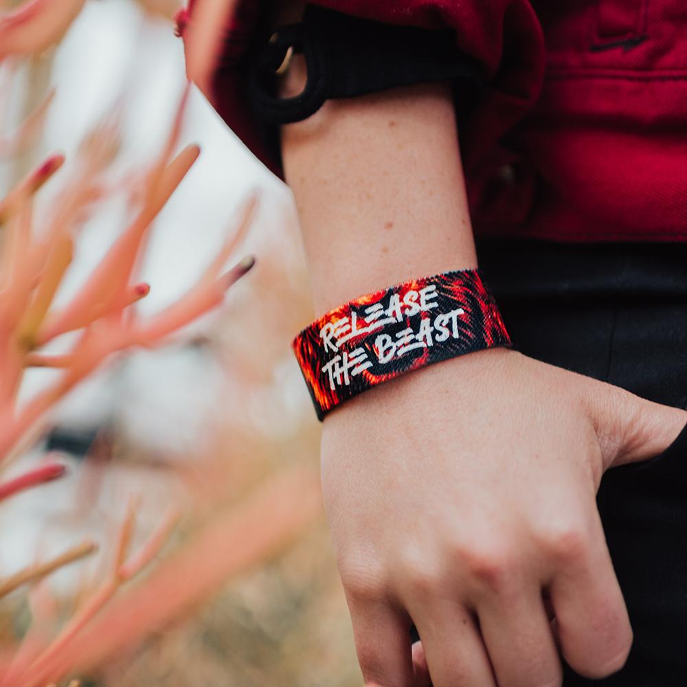 Lifestyle image close up of someone's hand in pocket with a Release The Beast on wrist