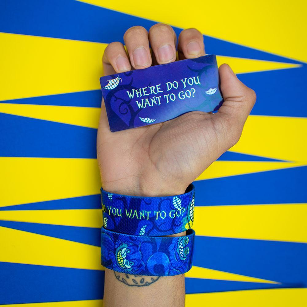 Studio image of hand holding a card that says Where Do You Want To Go? and wearing 2 Where Do You Want To Go? on their wrist