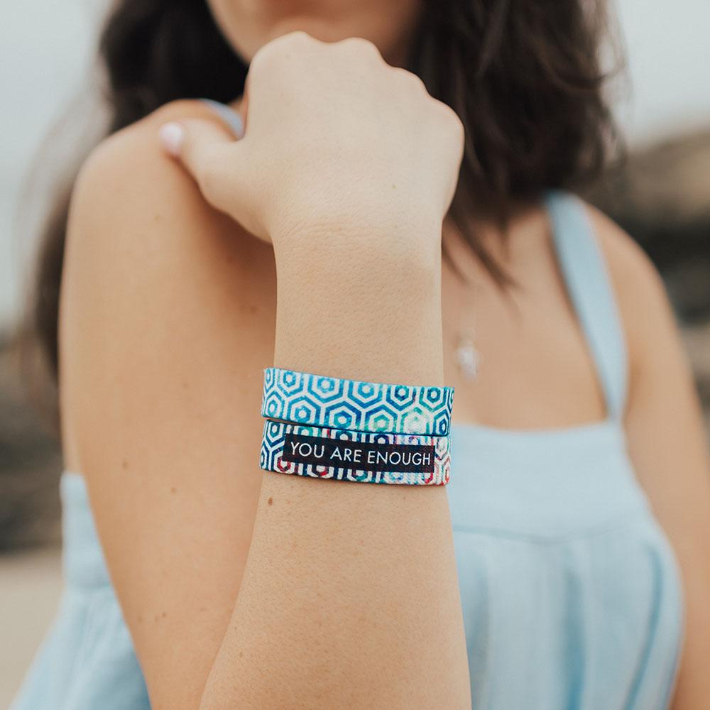 Lifestyle image close up of 2 You Are Enough on model's wrist