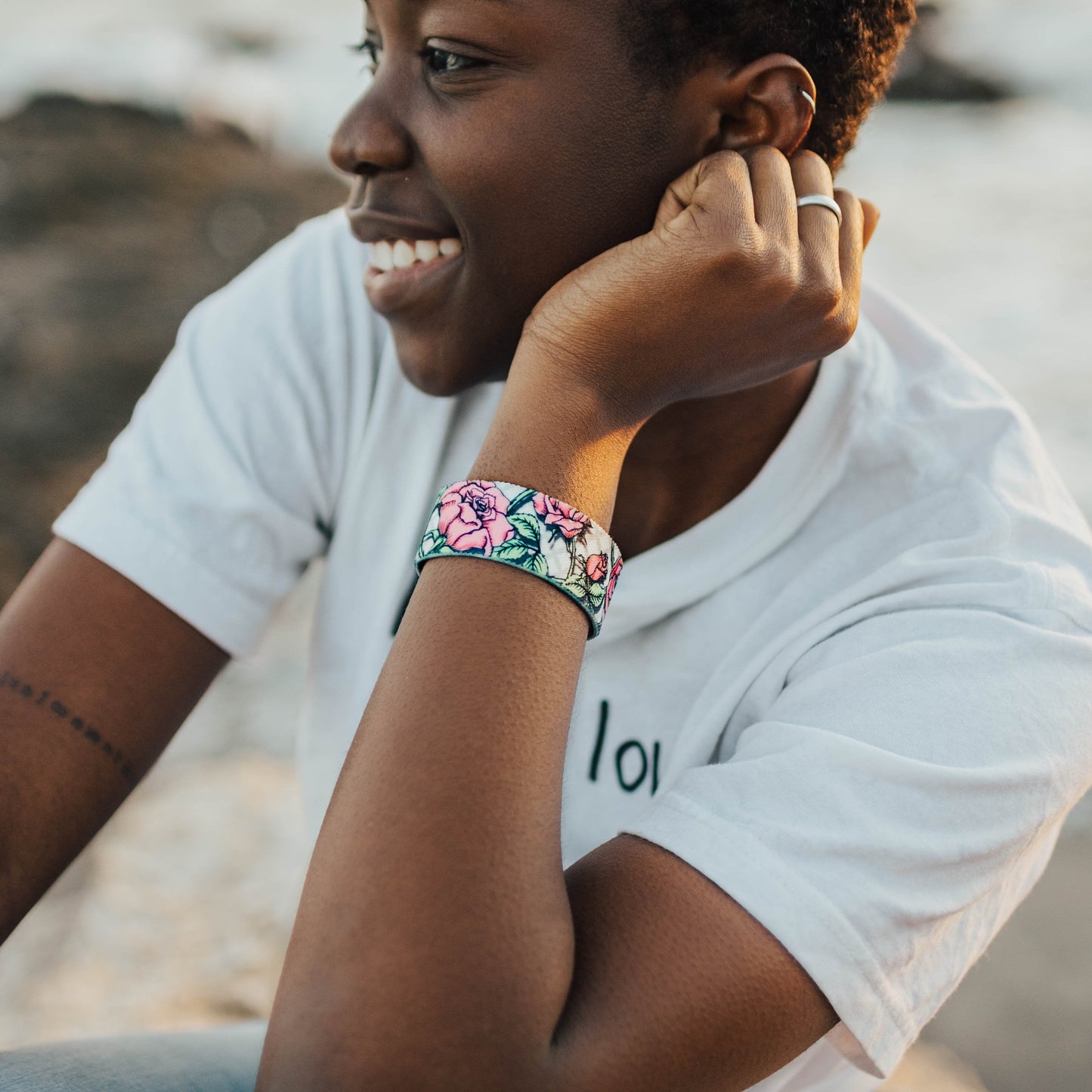 Lifestyle image close up of someone smiling with Thank You on their wrist 