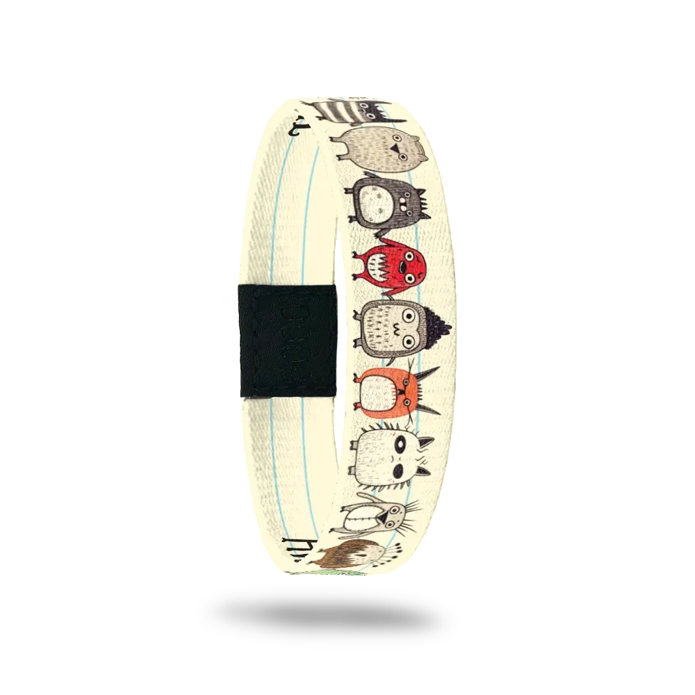 Beige colored single with thin white lines looks like notebook paper. Tiny, cute monsters holding hands along the whole wristband. Inside looks like notebook paper and says Awesome Is My Middle Name. 