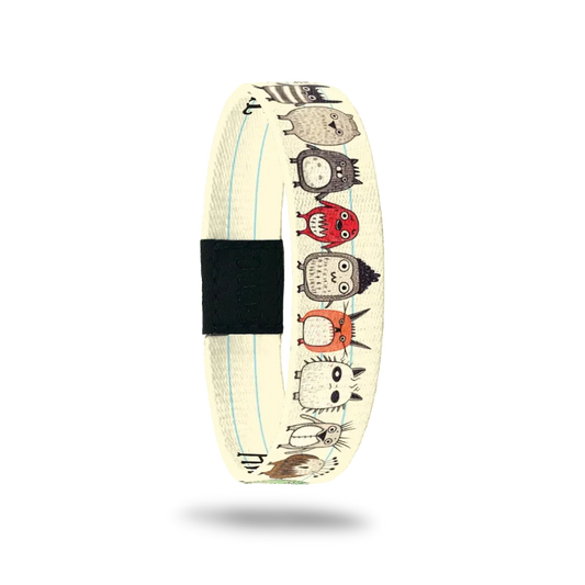 Beige colored single with thin white lines looks like notebook paper. Tiny, cute monsters holding hands along the whole wristband. Inside looks like notebook paper and says Awesome Is My Middle Name. 