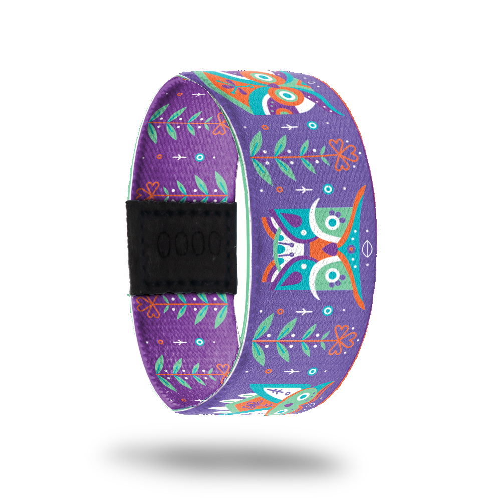 Purple strap with green, orange, white, purple ornate owls all over. Flowers in between each owl. Inside is the same without the owls and says Be Mindful. 