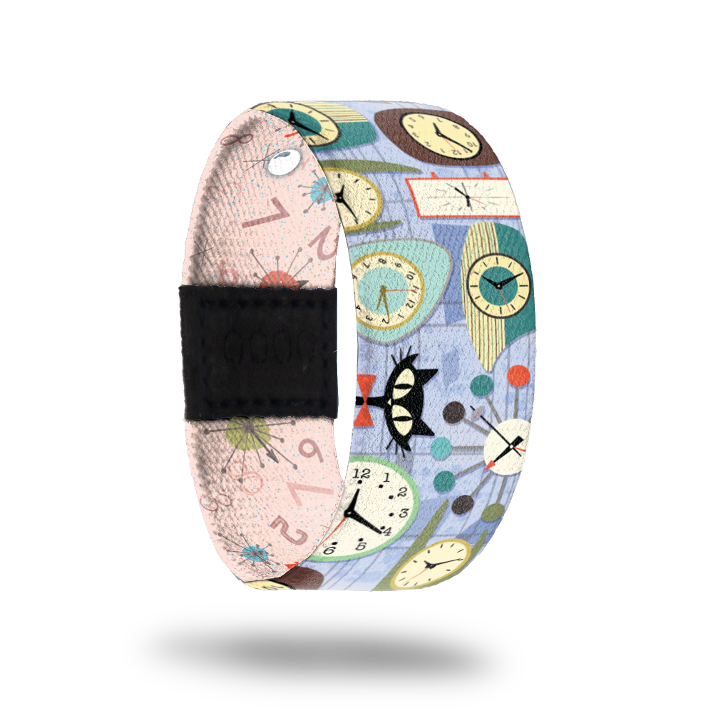 Pale blue strap with clocks and cats all over. Inside is pale pink with numbers and clocks all over and reads Better Late Than Never. Comes with a matching lapel pin and collector's box. 