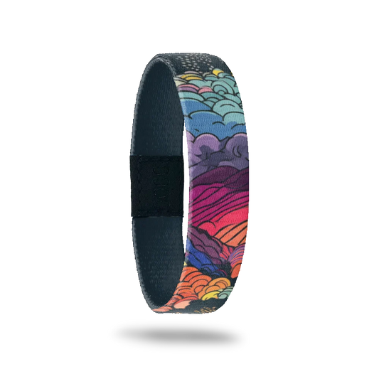 Design is mountains and waves crashing on the shore, all in multicolors with a dark grey sky and stars. Inside is dark gray and reads Beauty In The Storm. 