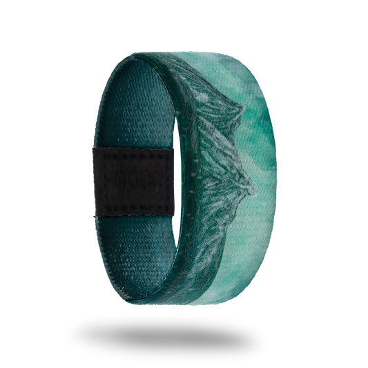 This is a reversible strap. The design is various colors of teal with the scene of mountains in the distance.  The inside is all teal gradient and says Beneath the Surface. It is reversible. 