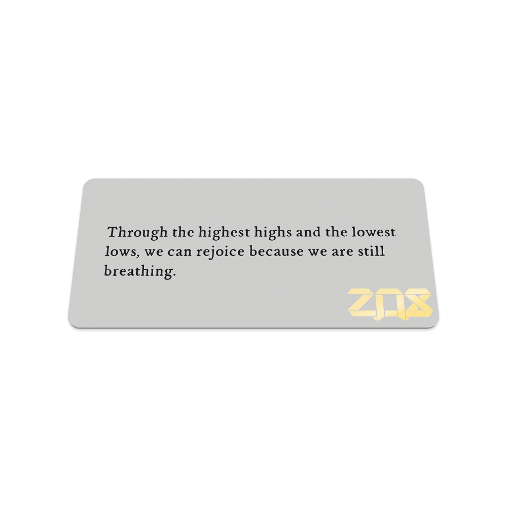 This is the back of the collector's card and in black text, it reads "Through the highest highs and the lowest lows, we can rejoice because we are still breathing."