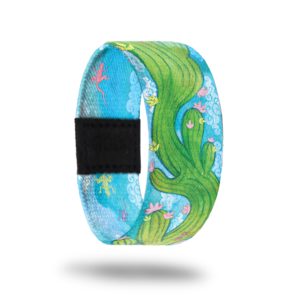 Outside Design of Endurance: light blue sky background with green cactus with pick and yellow flowers waving through the center of the strap