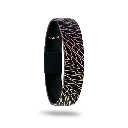 Wristband is black with gradient purple, pink and yellow swirls that are diagonal to the band.  Inside reads Forgiven.