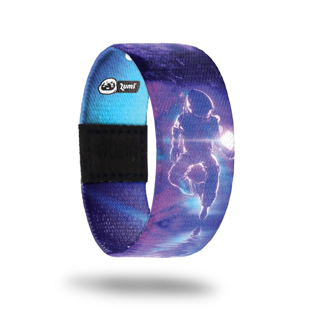 product image of the outside of a wristband named Higher Calling. It is mainly different hues of purple and is an astronaut in space