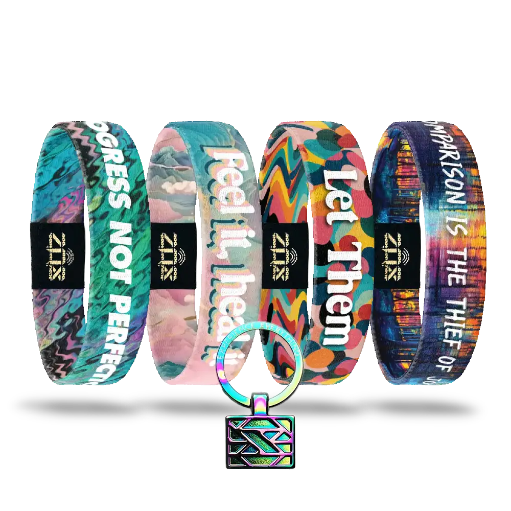 The Self-Care Pack features four vibrant affirmation bracelets with motivational phrases and abstract designs, displayed upright above a matching iridescent geometric keychain—a perfect set for daily inspiration.