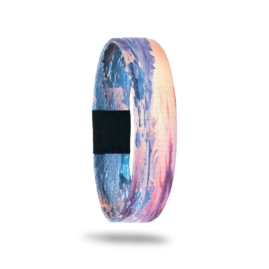 Wristband single with a sunset view of icebergs and the shoreline with blue, pink, orange and yellow. The inside is the same and reads Ice Age.