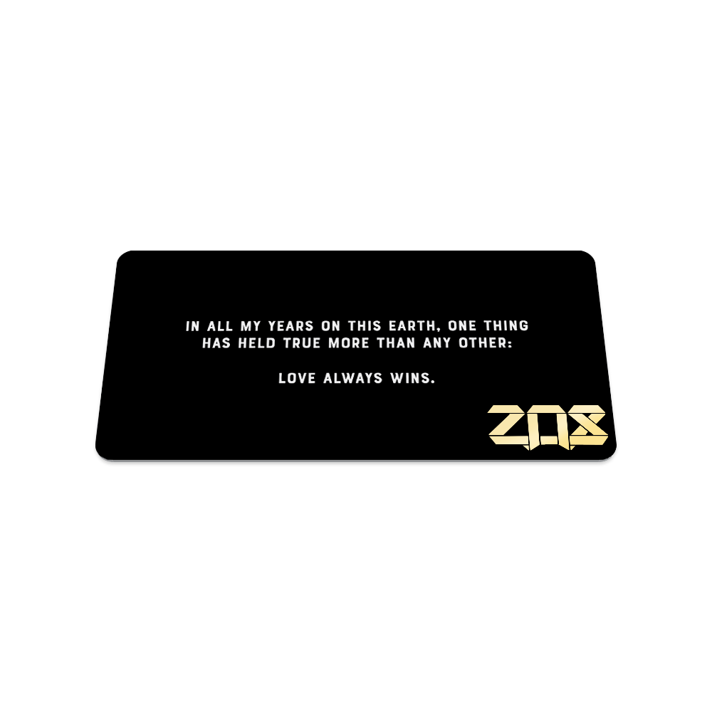 Back of collector's card is plain black. White text says "In all my years on this earth, one thing has held true more than any other: Love Always Wins."