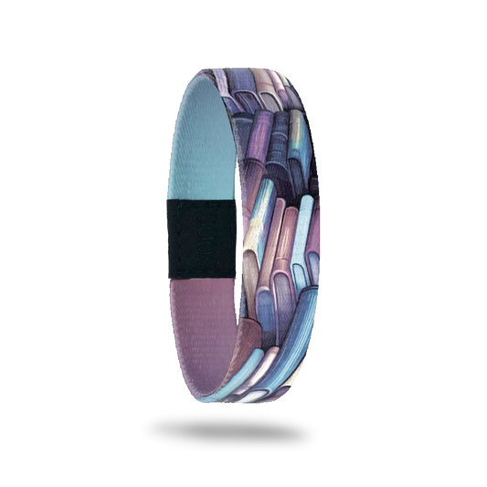 Wristband single with purple and blue books on a shelves all over. The inside is blue and purple gradient and reads Page Turner.