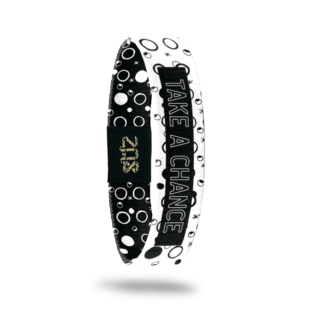 Inside design for Take A Chance. White background with black filled and outlined circles. Centered is a black rectangle with Take A Chance in white outlined text