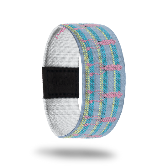 Product photo of the outside of SquidGoals: pastel blue design with repeating teal and lime green stripes, repeating pink squid