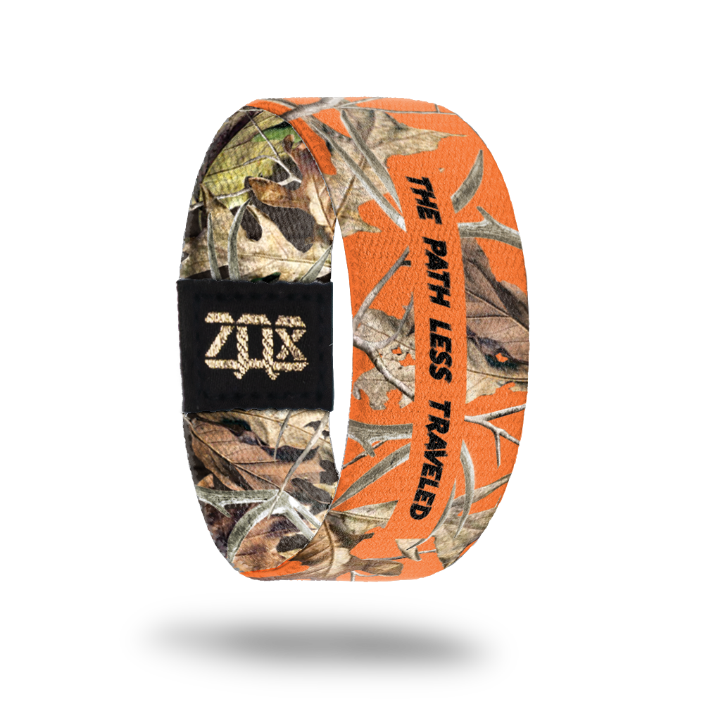 Inside Design of The Path Less Traveled: orange background with green, yellow, and brown leaves and sticks and dark brown text overlaying ‘The Path Less Traveled’