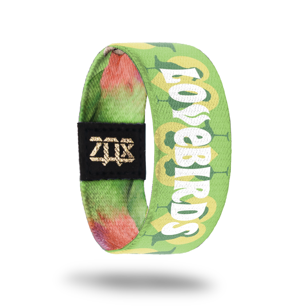 Still image of inside design for parrot. Light green background with yellow hearts and the full bird body silhouettes in a dark green for the background. Lovebirds in the center in large bold text