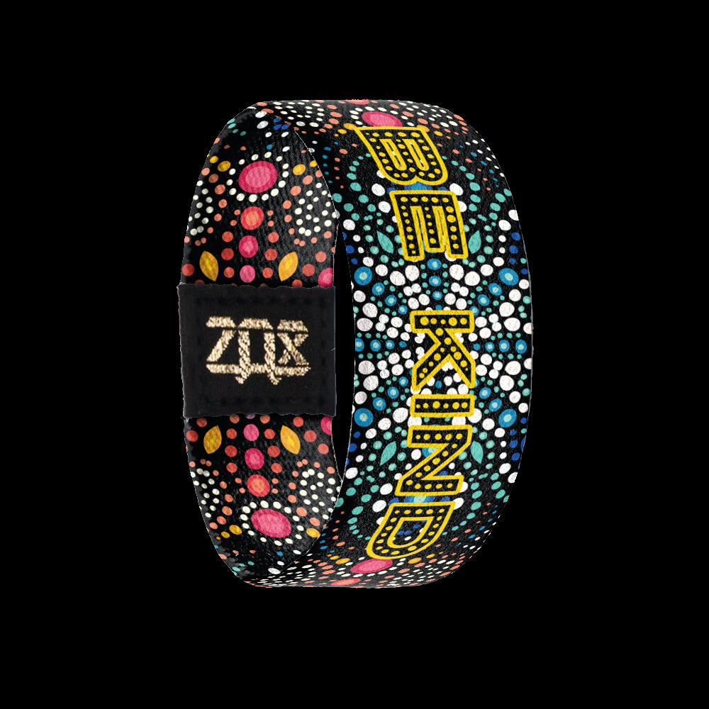 Inside design of Be Kind is of dot art in a mandala style in white, green, blue, pink, and yellow dots with the words Be Kind in yellow dots over the white, green, and blue dots in the center