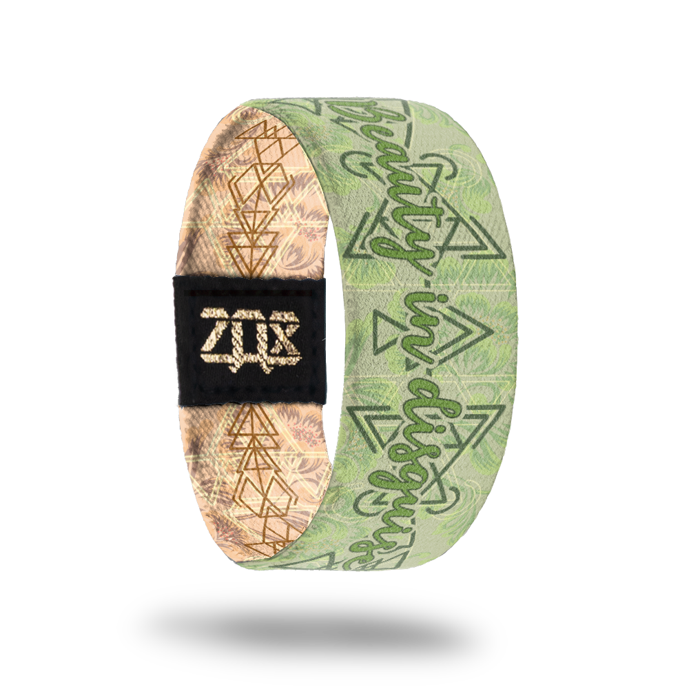 Inside Design of Beauty in Disguise: pale green background with dark green geometric designs and Beauty in Disguise in the center