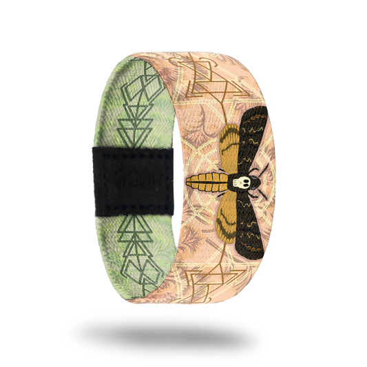 Outside Design of Beauty in Disguise a tan design with cream and brown geometric details with a moth in the center