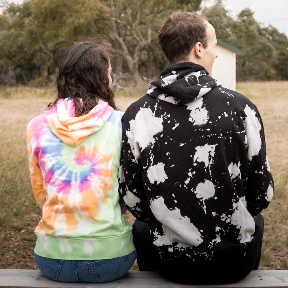 Back of Jordan and Sarah, sitting on a bench wearing the hoodies.