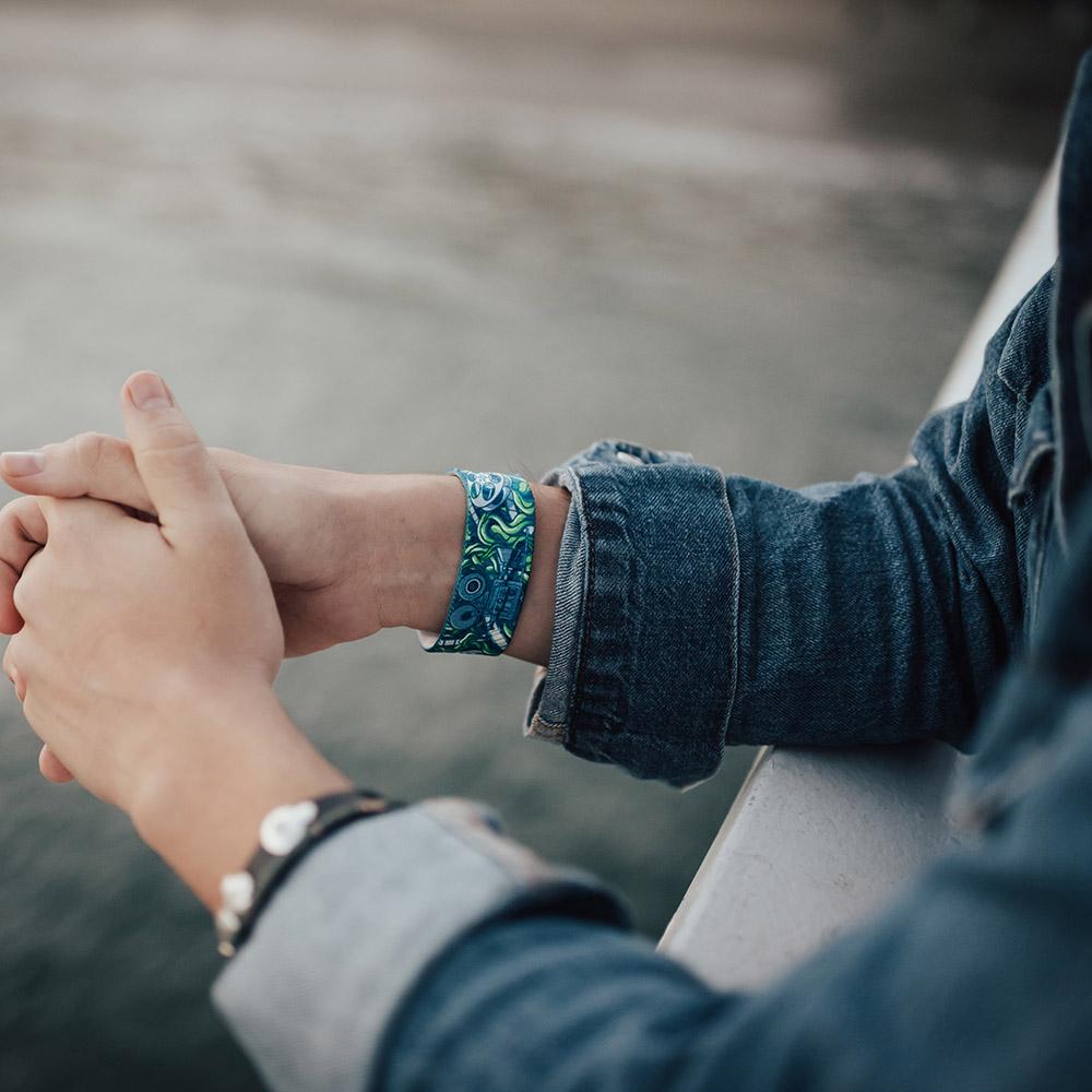 Lifestyle image of someone's arms resting on a railing with Cinephile on one wrist