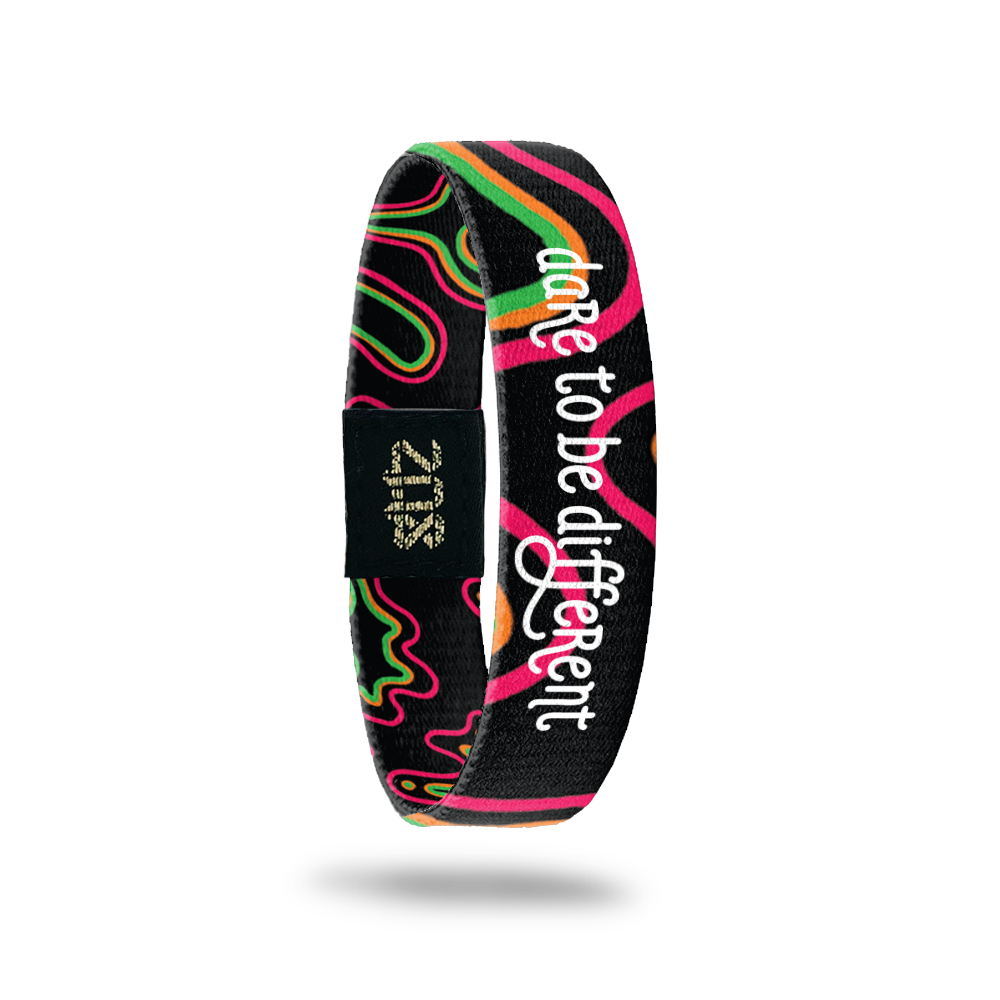Outside Design of Dare to Be Different: black background with pink, orange and green in zoomed in irregular shapes throughout the single