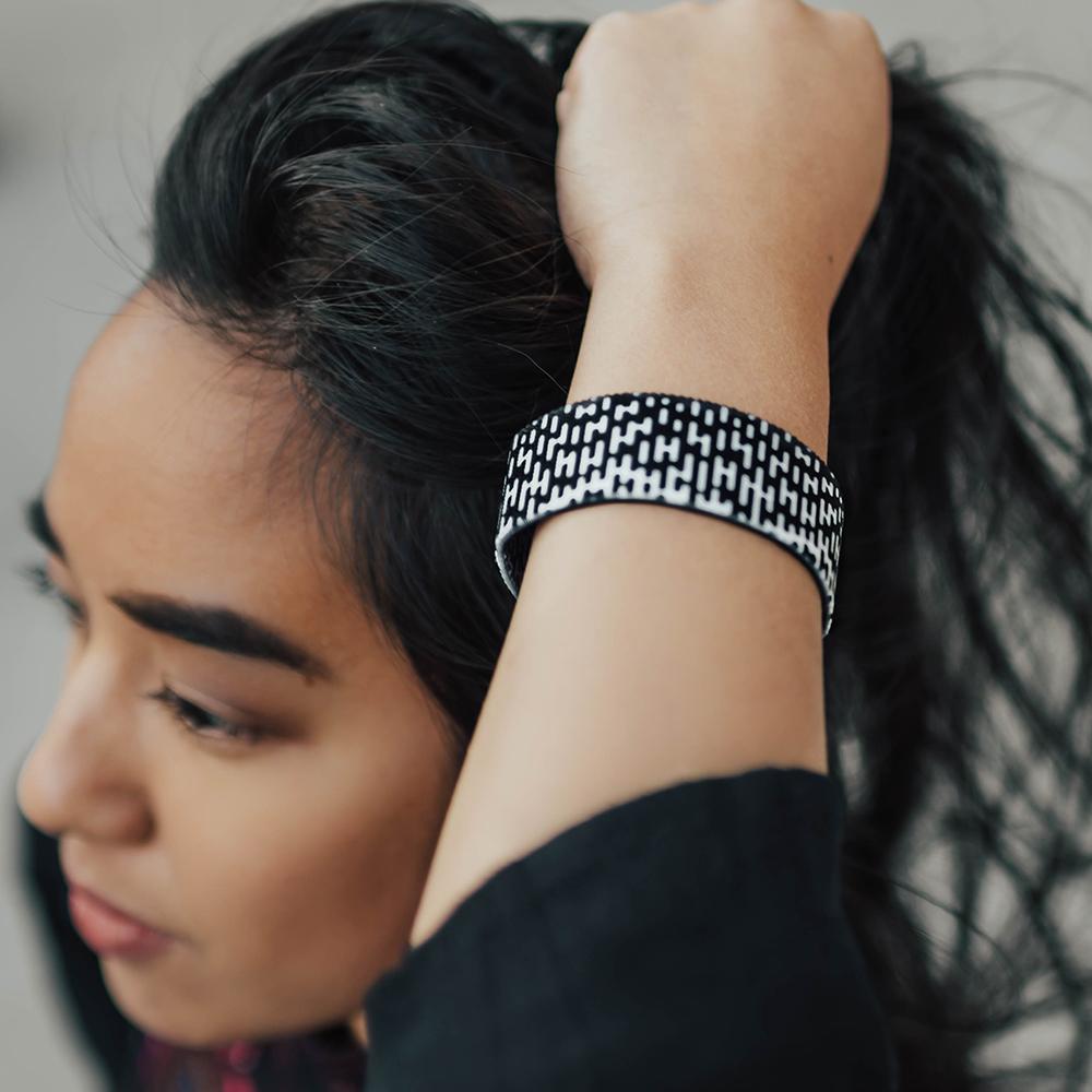 Studio image close up of Do on wrist of someone with their hand in their hair