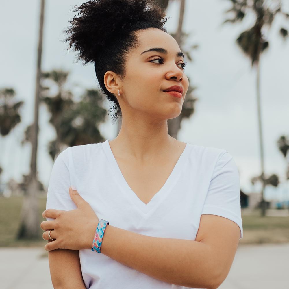Lifestyle photo of girl wearing do my best single showing the outside design with fish scales of a variety of scales of blue, coral, and purple gradient coloration