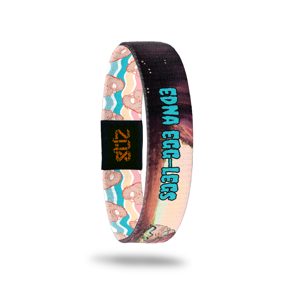 Product photo of the inside of 2020 - Day 31 - Edna Egg-Legs: cave design with furry, peach monster inside a yellow and green egg-shell with teal 'EDNA EGG-LEGS' text