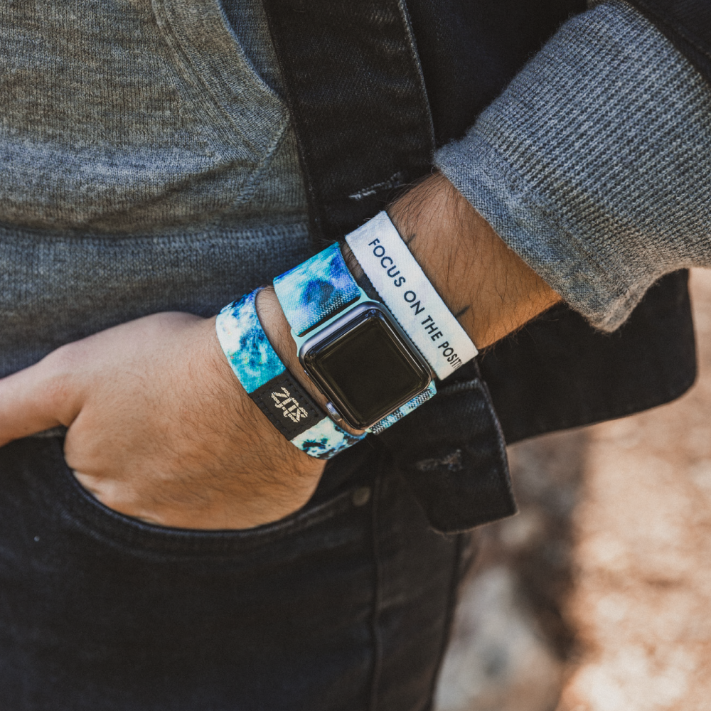 This is a lifestyle photo of someone with their hand in their pant's pocket. They are wearing the watchband on an Apple watch. The have the matching wristband on either side of the watch, one showing the outside and one showing the inside. 