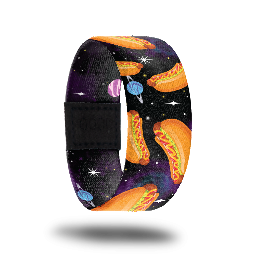 Outside design of Franks In Space. Dark space background with a few small illustrated planets and larger cartoon illustrated hotdogs with condiments spread across randomly