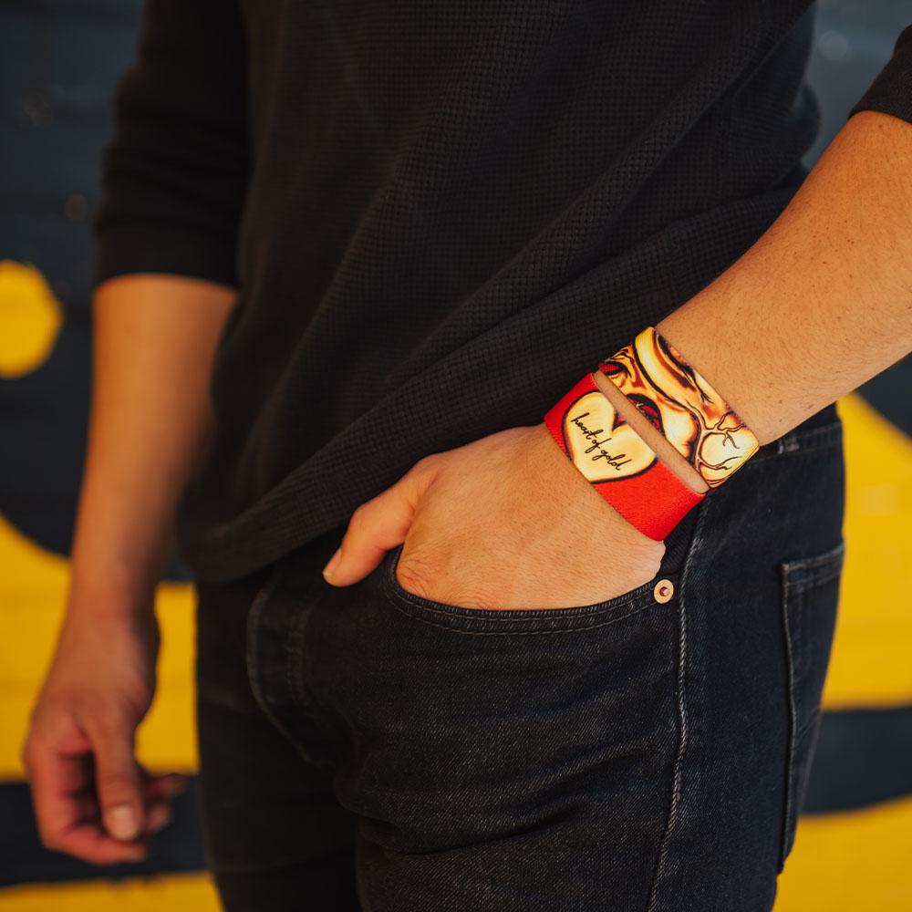 Personal image of 2 Heart of Gold wristbands on wrist, hand in pocket. 
