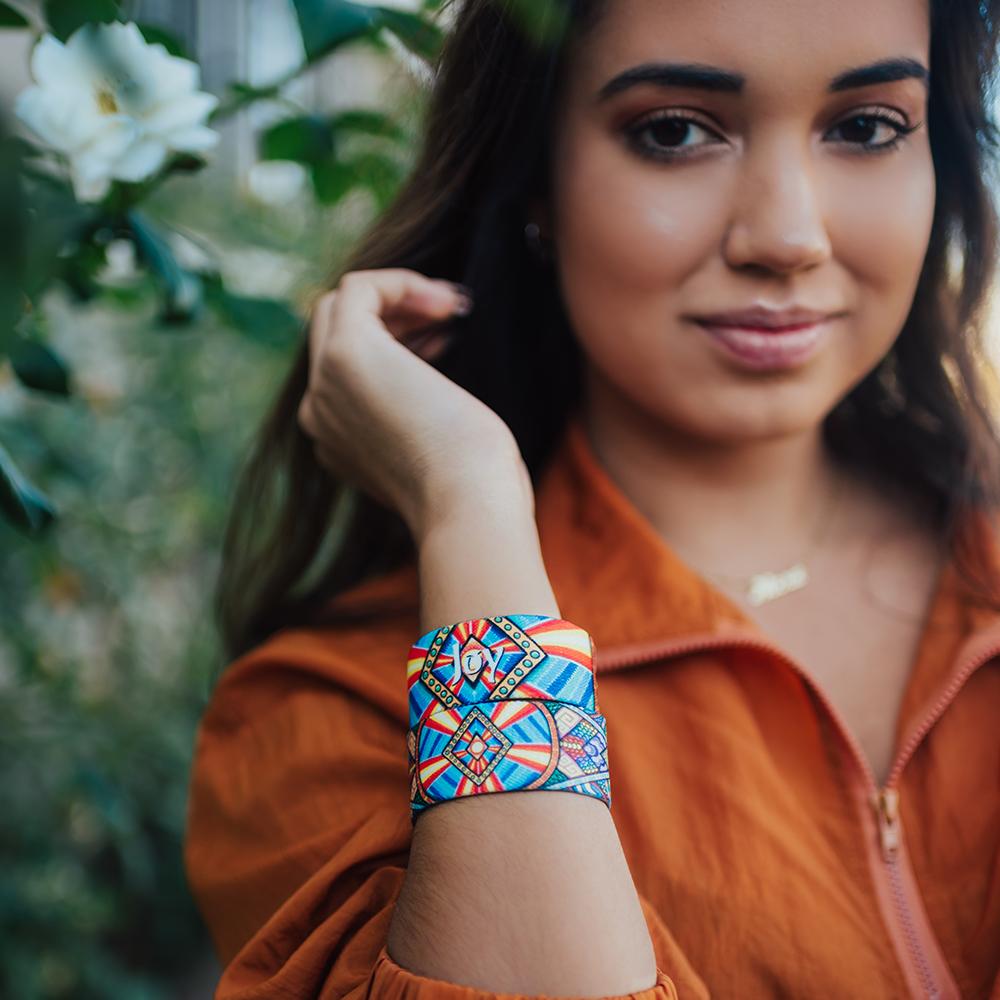 Lifestyle image portrait image of someone wearing two Joy straps on one arm