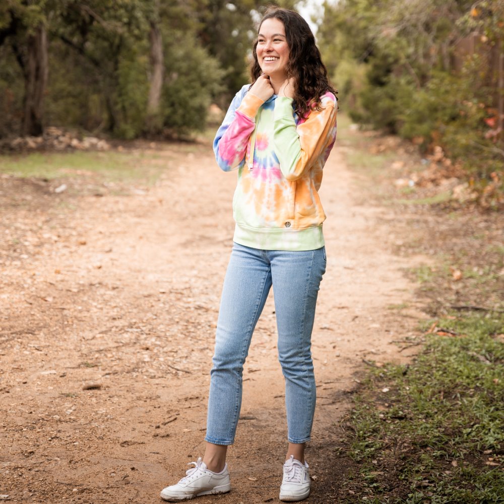 Photo of Sarah wearing hoodie in the woods. 