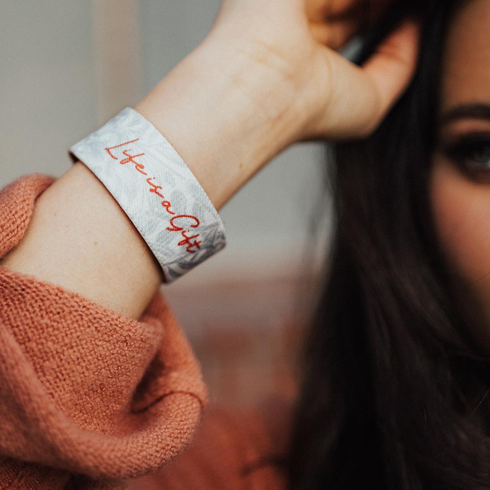 Lifestyle close up of Life Is A Gift on someone's wrist