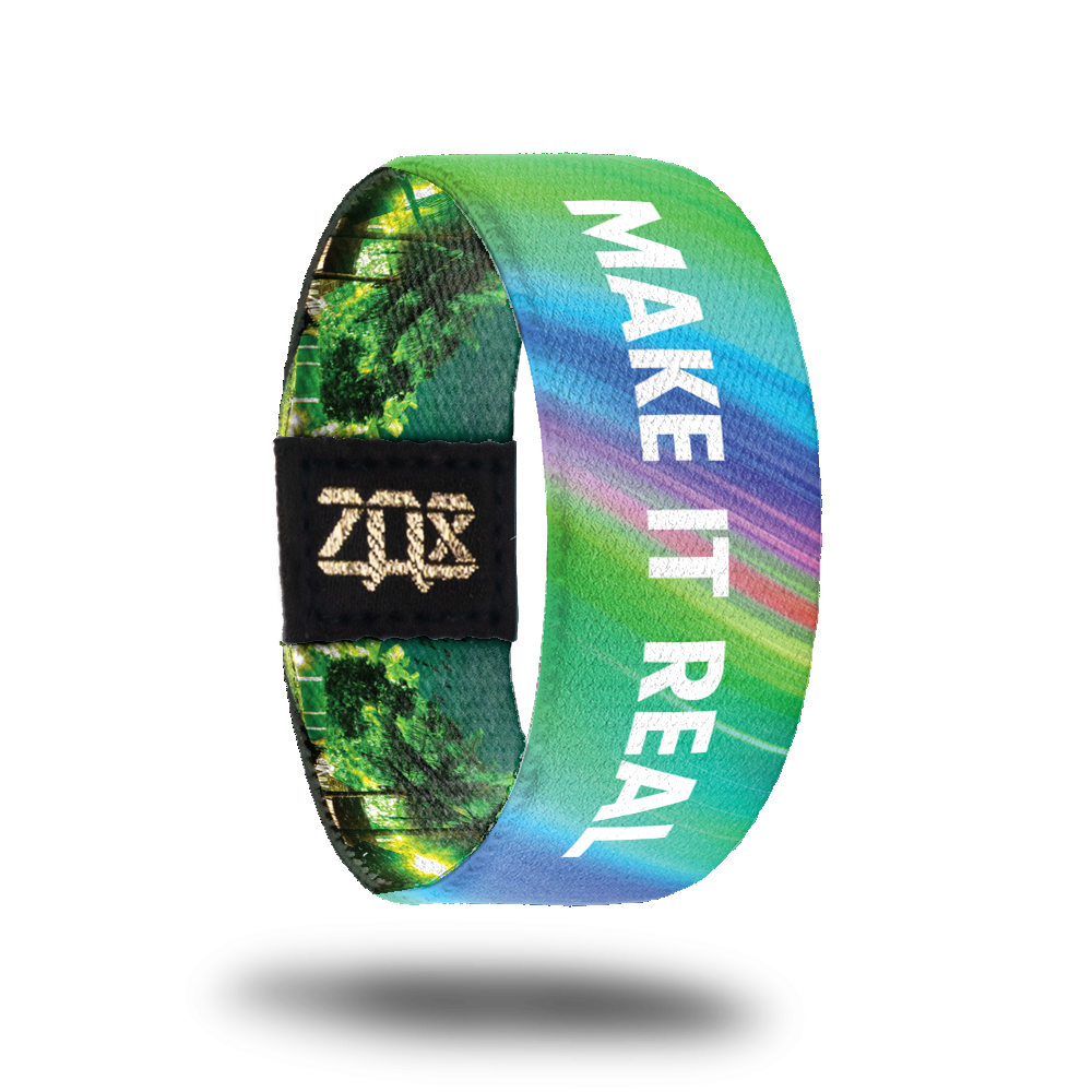 Inside design of Make It Real. Mostly a light green background with faded rainbow color streaks behind the white text of Make It Real in the center