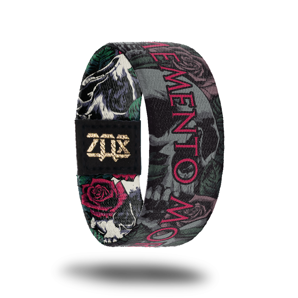Inside design for Memento Mori. Gray illustrated realistic skulls, roses, and leafs with Memento Mori in red text at the center
