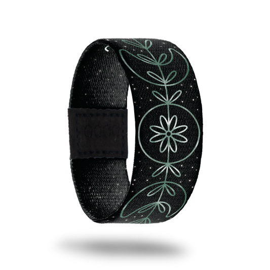 Outside is black with gradient teal fine line designs. It has moons and circles in the center. Inside is black with stars and reads "Moonchild"