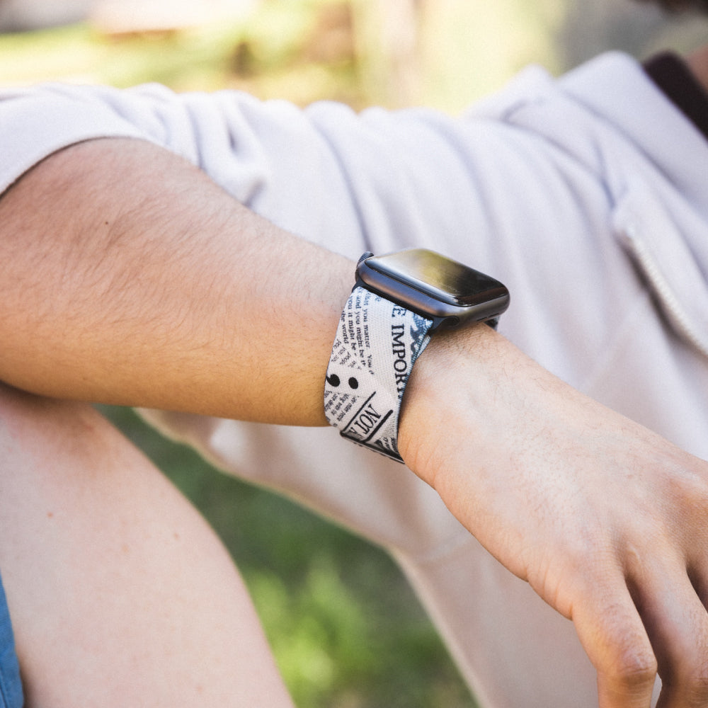 Lifestyle photo of someone resting their forearm on another person's shoulder. They are wearing a beige jacket with the sleeve rolled up and wearing the My Story Isn't Finished on an Apple watch. 