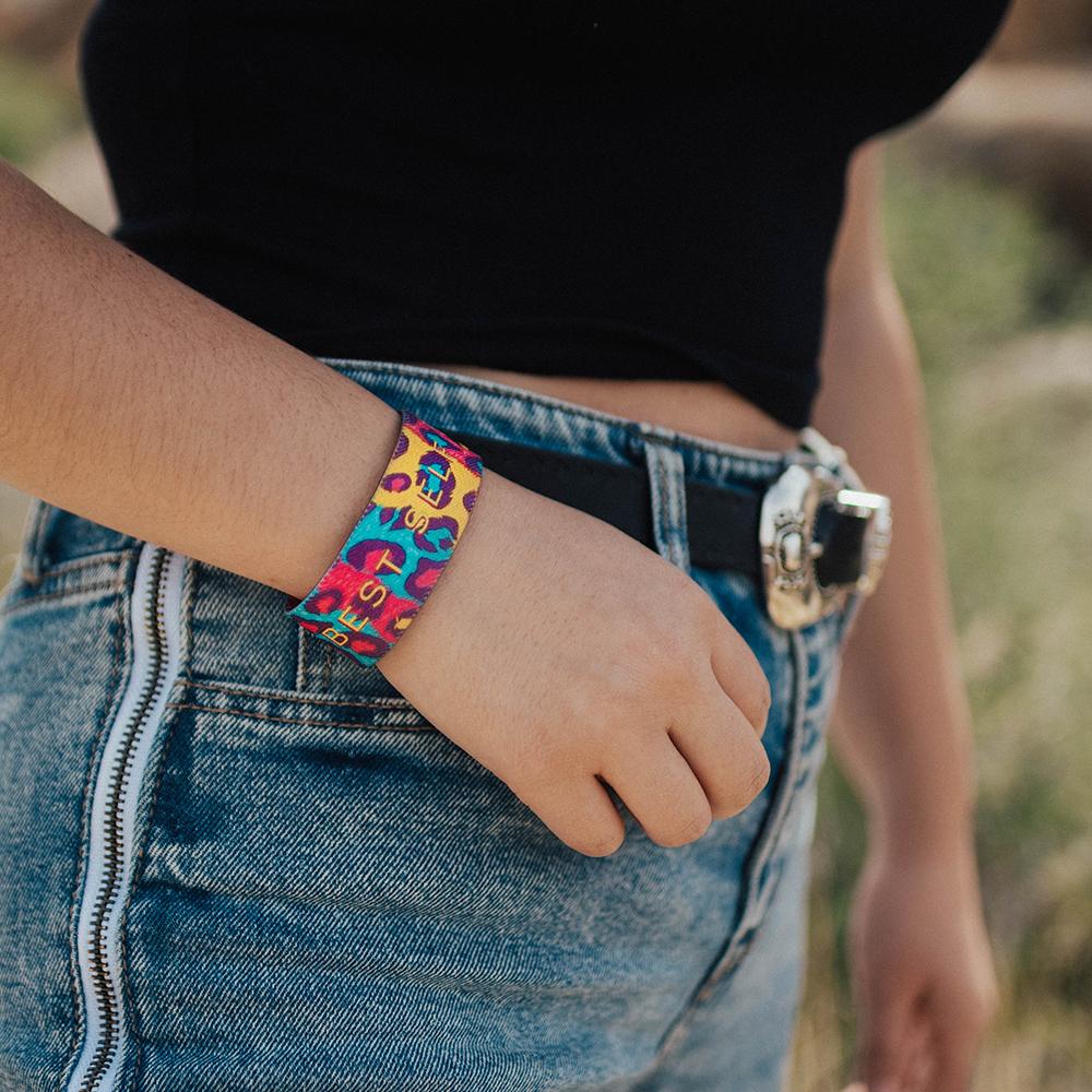 Lifestyle image close up of model's hand on pant's pocket with My Best Self on wrist