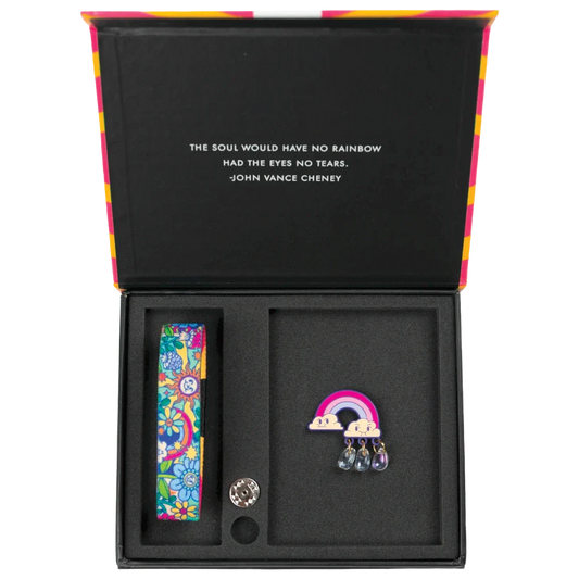 Outside is brightly colored scene of rainbows, flowers, the smiling sun, etc. Comes with a matching lapel pin of a rainbow with smiling clouds and little prism raindrops. Comes with a matching collector's box. 