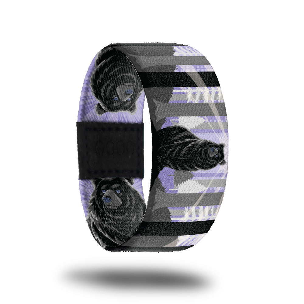 Outside Design of Stand Tall: purple background with white, grey, and black tree forest and a bear in the middle